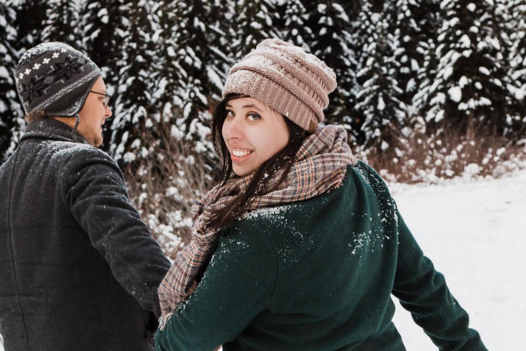 couple walking in snow holding hands