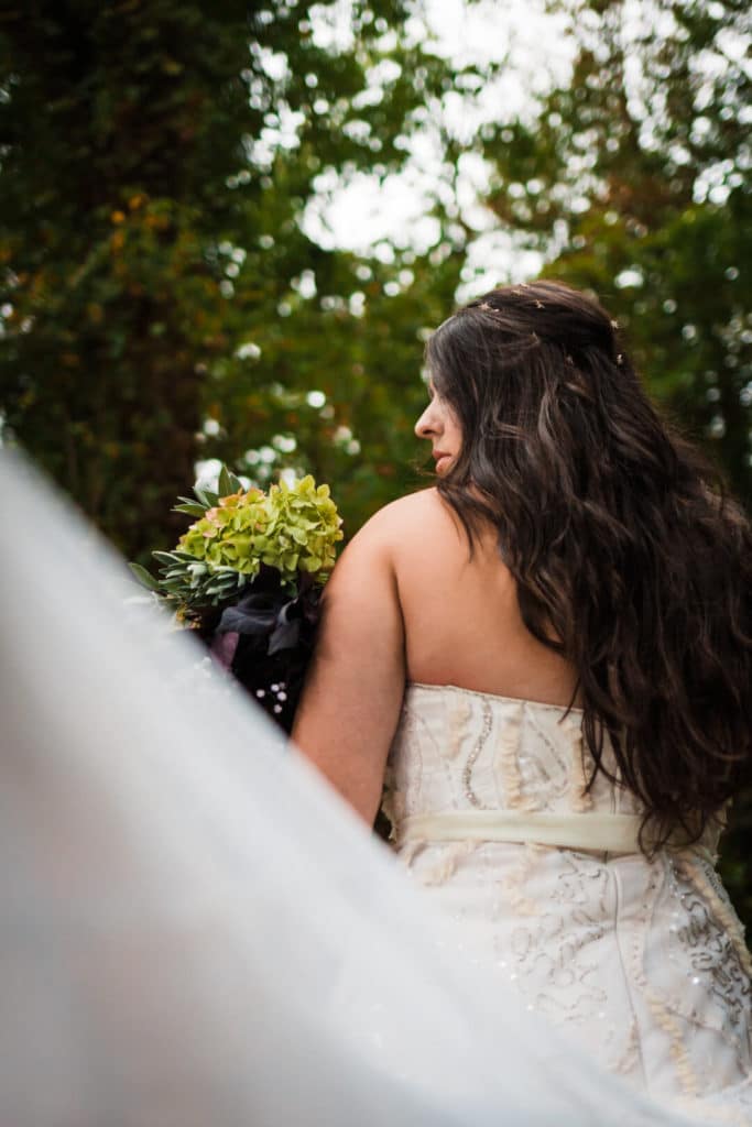 bride looking over her should with her wedding bouquet