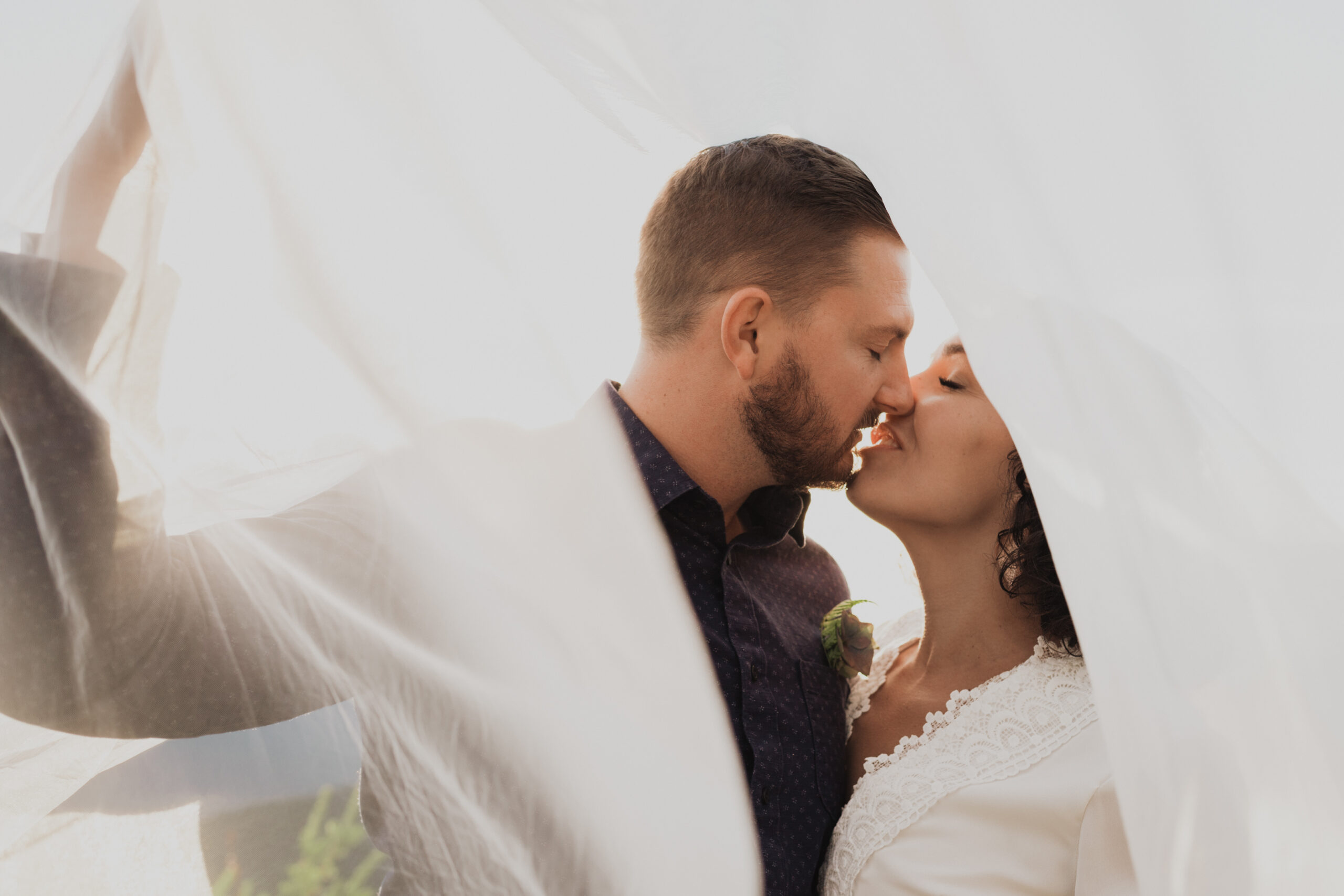 two people kissing under a wedding veil